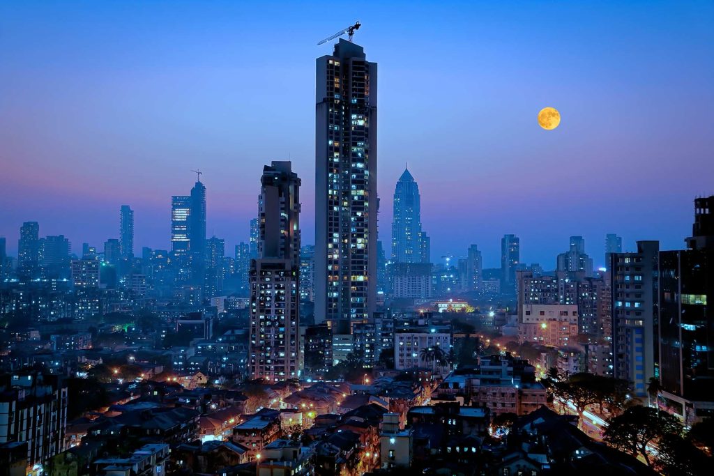 Moonrise over south central Mumbai - the financial capital of India - showing a glittering metropolis with a reputation of city that never sleeps with dwellings of lower middle class in foreground and newer towers where elite stay in the far background.