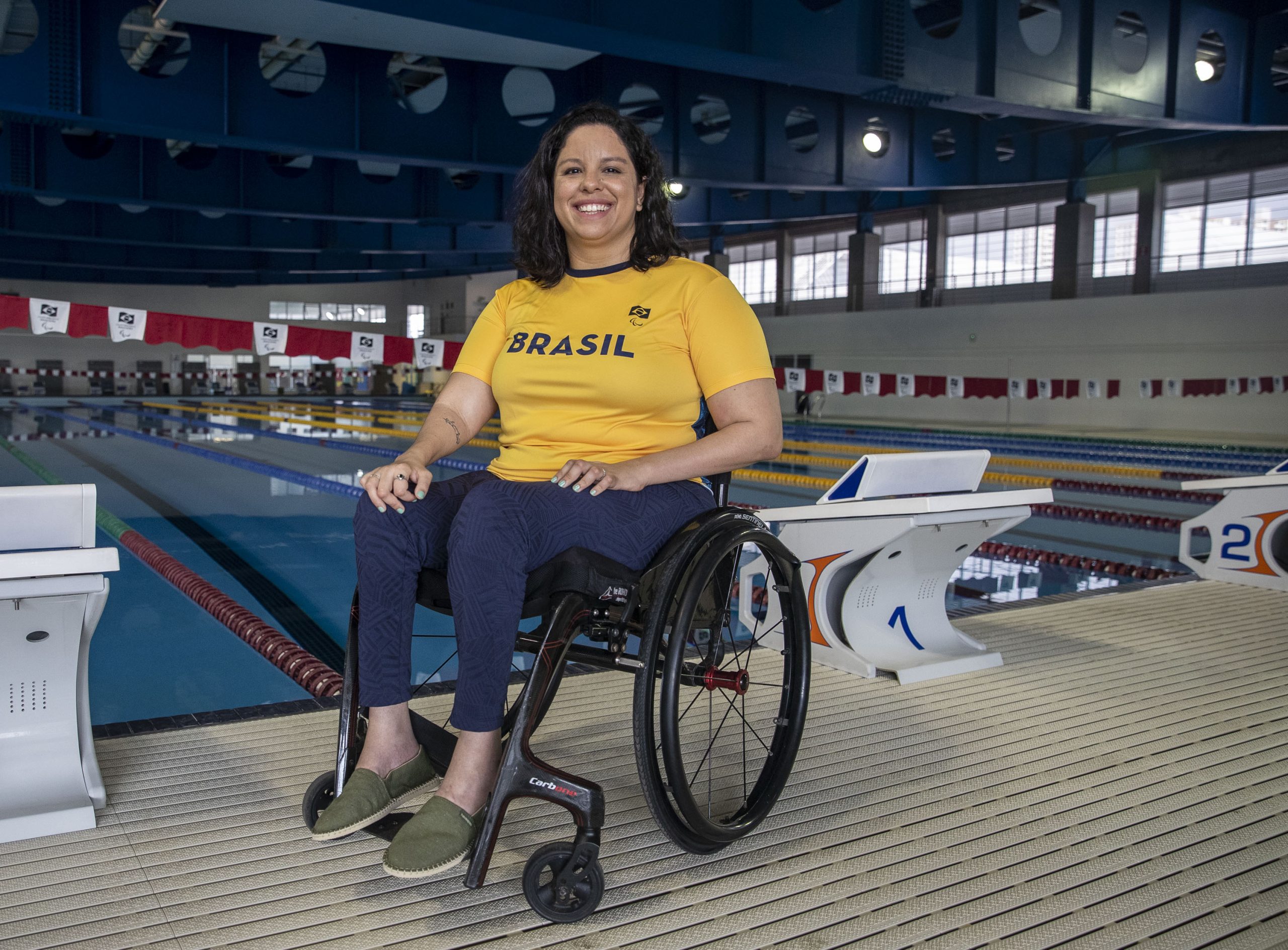 Edenia Garcia sitting in wheelchair smiling at the end of the pool