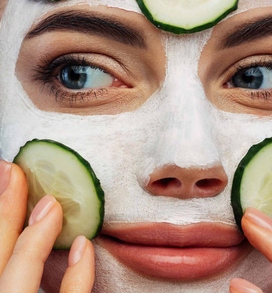 Close-up shot of a mom enjoying home spac with mud mask and cucumbers on her face