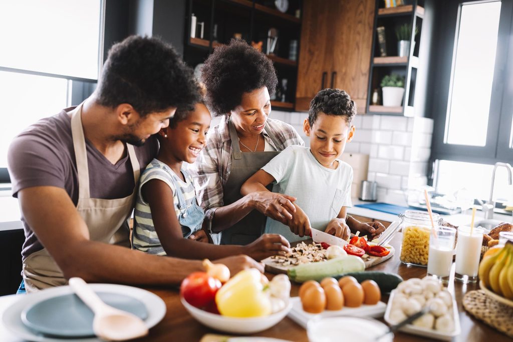 A family cooking together with mom.